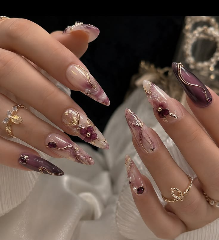 Deep plum marble stiletto nails with sculpted floral accents and gold detailing