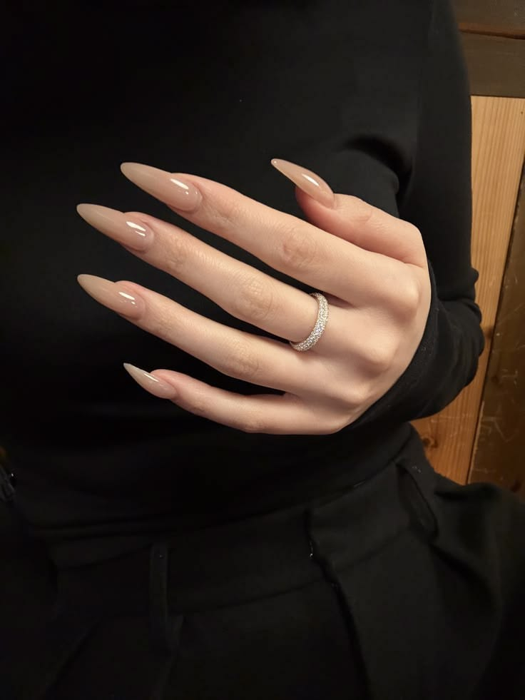 Long stiletto gel nails with glossy natural nude beige polish